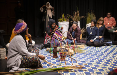 People sitting on the floor taking part in a weaving workshop