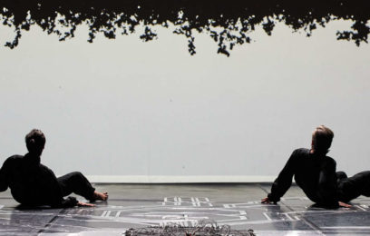 Chamber Made - Two figures sit on the floor with their back facing us. There is a plain white background with a leafy silhouette on the roof.